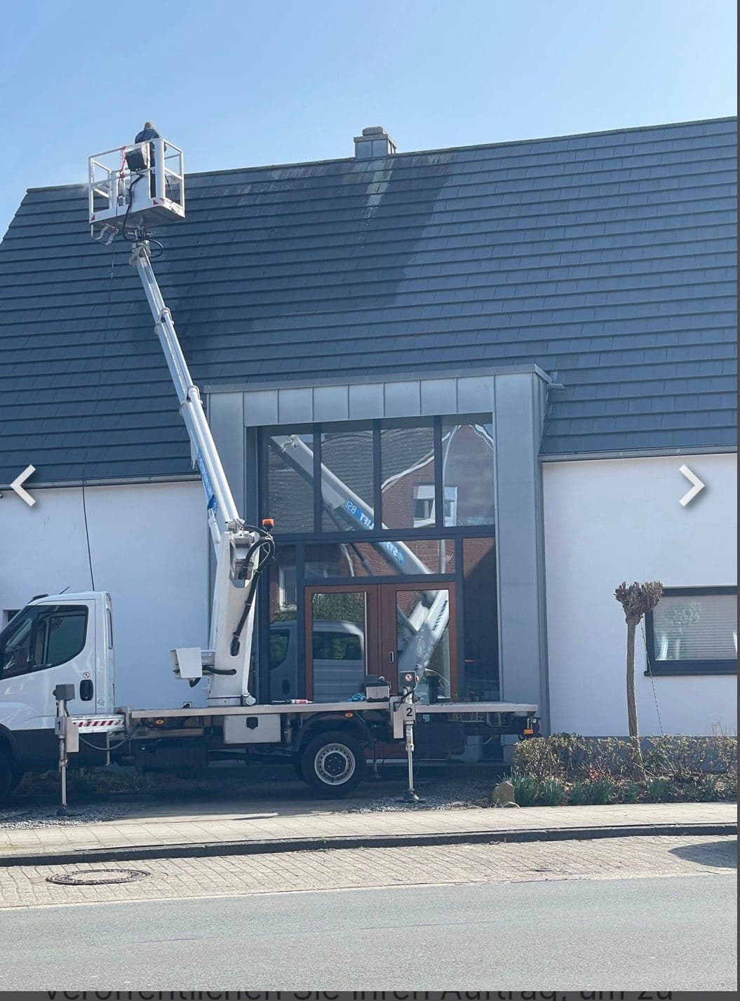 Mitarbeiter im Hubsteigerkorb am Dach